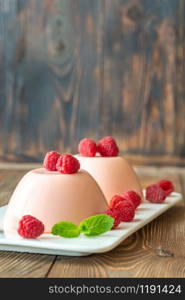 Dessert puddings decorated with fresh raspberries and mint leaves