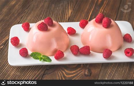 Dessert puddings decorated with fresh raspberries and mint leaves