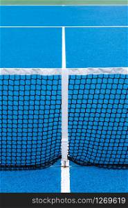 Detail of a Blue Tennis court with black net on Outdoor. Sport background