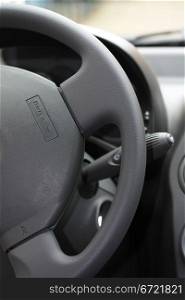detail of a car interior, steering wheel with airbag