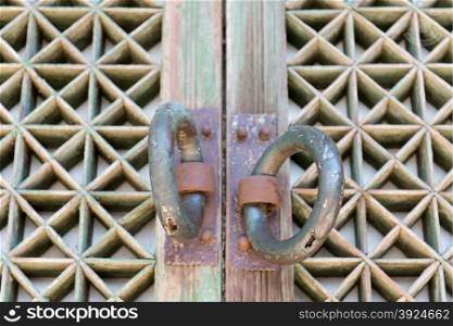 Detail of a door at a buddhist temple. Detail of an old wooden door at a buddhist temple with door handles
