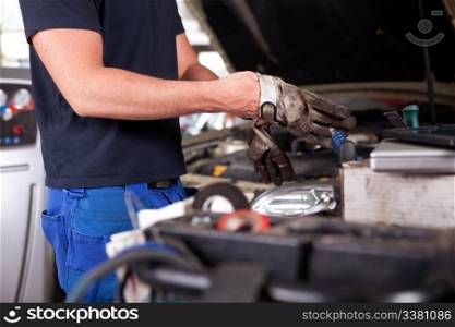 Detail of a mechanic putting on dirty work gloves