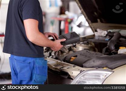 Detail of a mechanic using electrnoic diagnostic equipment to tune a car
