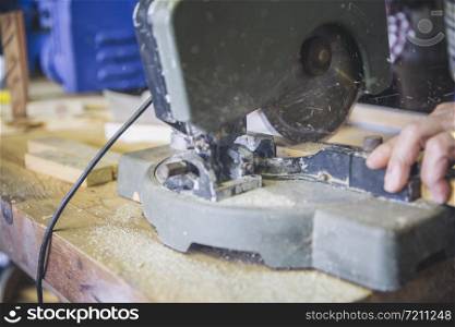 Detail of a miter machine working in a carpentry shop. Detail of a miter machine