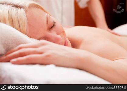 Detail of a relaxed woman receiving a back massage at a spa