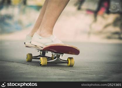 Detail of a young woman feet riding a skateboard