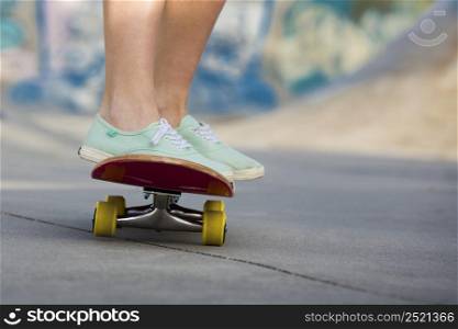 Detail of a young woman feet riding a skateboard