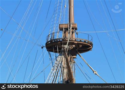 Detail of an ancient ship mast with bright blue sky