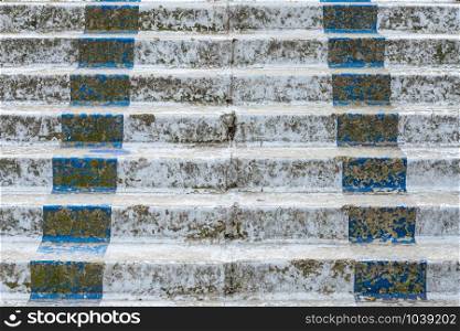 Detail of an old and broken white and blue concrete stairway
