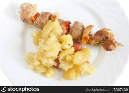 detail of baked pork kebab with potatoes on a dish