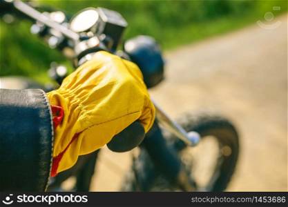 Detail of biker&rsquo;s hand with gloves grabbing the handlebar of the motorbike. Biker&rsquo;s hand with gloves grabbing the handlebar