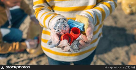 Detail of boy hands with garbage collected from the beach. Boy hands with garbage from the beach