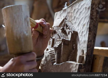 Detail of caucasian middle aged scultor working on wood, natural daylight