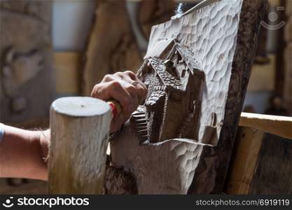 Detail of caucasian middle aged scultor working on wood, natural daylight