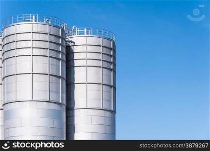 Detail of chemical plant, silos and pipes. Copy space