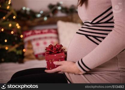 detail of christmas girt box against pregnant belly