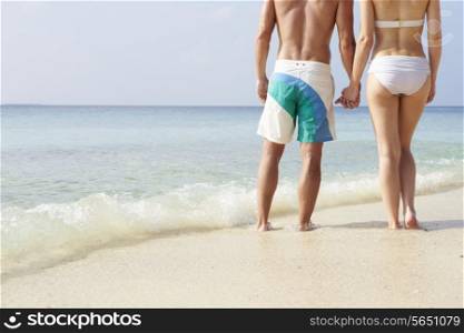 Detail Of Couple Holding Hands On Beach Holiday