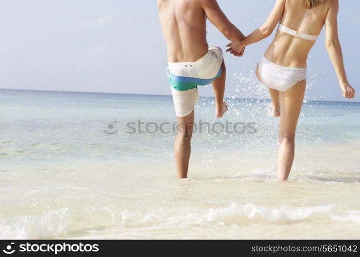 Detail Of Couple Splashing In Sea On Beach Holiday