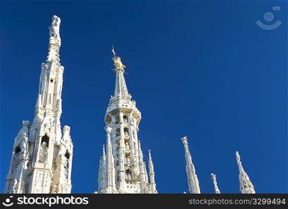 Detail of Duomo di Milano (Milan Cathedral) with the famous &acute;Madonnina&acute; (the symbol of Milano) atop the main spire of the cathedral, a baroque gilded bronze artwork.