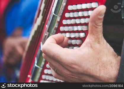 Detail of fingers on bass keys on an accordion at a folk festival