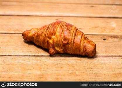 Detail of fresh croissant on wooden table. Food and breakfast concept. Top view and copy space. Detail of fresh croissant on wooden table. Food and breakfast concept. Top view and copy space