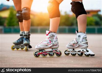Detail of girls rollerblading with knee pads