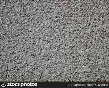 Detail of grey bumpy plaster surface of exterior wall in sunny day, close-up