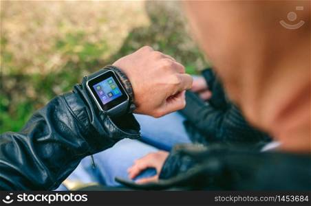 Detail of hand of unrecognizable young man looking at his smartwatch. Unrecognizable young man looking at his smartwatch