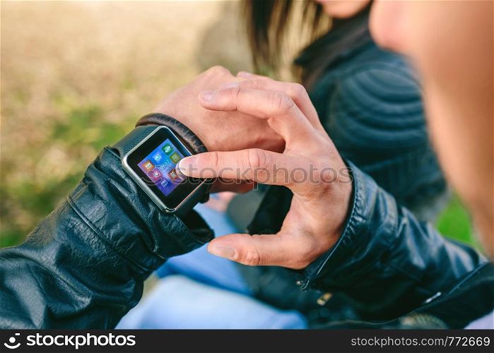 Detail of hand of unrecognizable young man using his smartwatch. Unrecognizable young man using his smartwatch