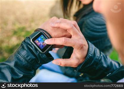 Detail of hand of unrecognizable young man using his smartwatch. Unrecognizable young man using his smartwatch