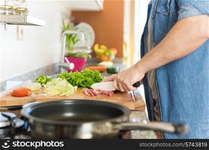 Detail of man in kitchen cooking healthy lunch