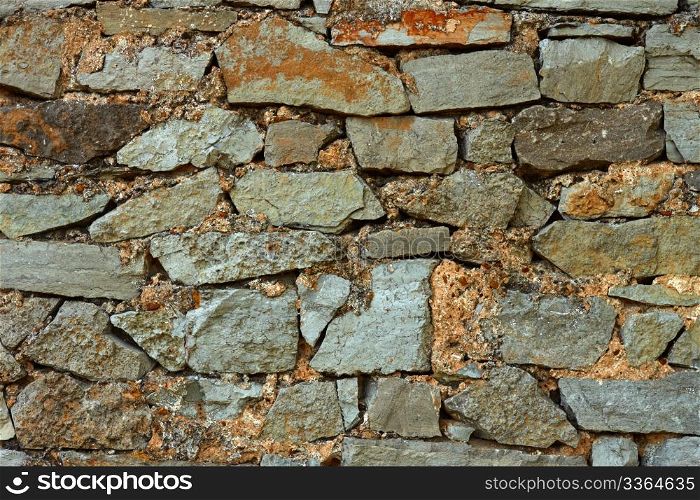 Detail of multicolor stone wall with coarse formless colored stones