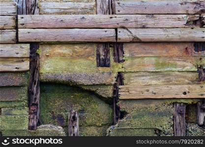 Detail of old pier, wooden planks weathered, crossing and decaying.