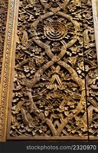 Detail of old wooden panel with floral carving and painting ornament