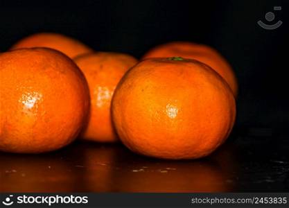 Detail of orange fruit on black background