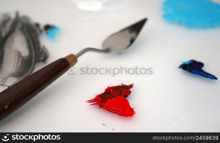 Detail of paint brushes and bright paint in an artist’s studio