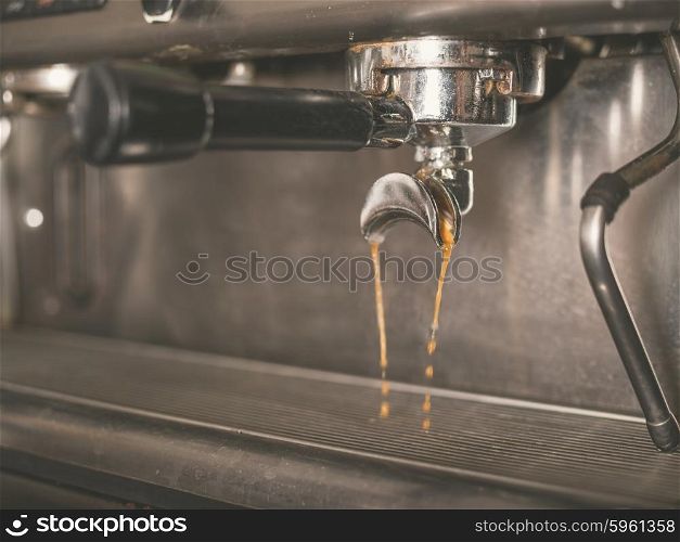 Detail of professional coffee machine with coffee brewing and dripping from the tap