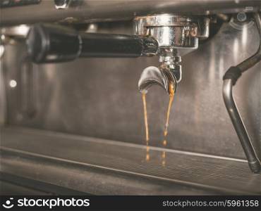 Detail of professional coffee machine with coffee brewing and dripping from the tap