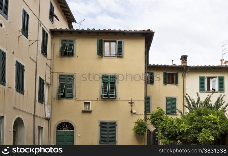 Detail of residential buildings with green window shutters in the town of Lucca, Tuscany, Italy.