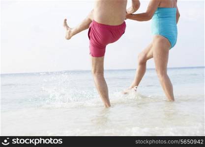 Detail Of Senior Couple Splashing In Sea On Beach Holiday