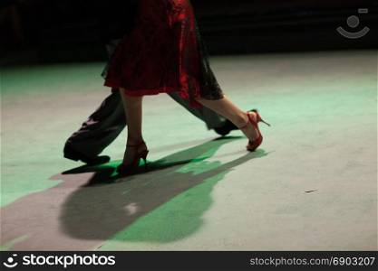 Detail of shoes with shadows in milonga ballroom.