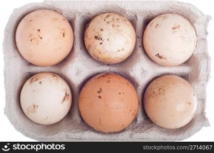 detail of six dirty eggs in a carton box isolated on white background