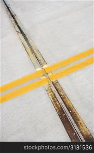 Detail of solid double yellow line in road crossing metal strips in cement.