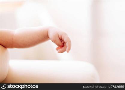 detail of the hand of a two weeks old newborn in studio lighting against white