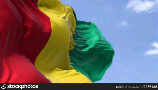 Detail of the national flag of Guinea waving in the wind on a clear day. Guinea is a coastal country in West Africa. Selective focus.