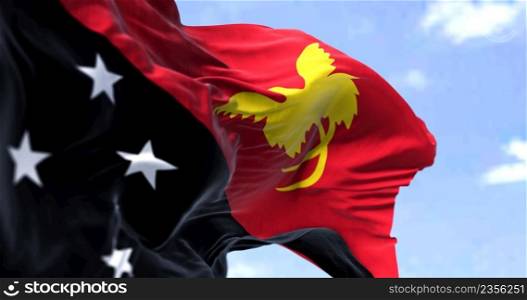 Detail of the national flag of Papua New Guinea waving in the wind on a clear day. Papua New Guinea is the world’s third largest island country. Selective focus.