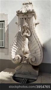 Detail of the public water fountain built in 1775 depicting a marble carved dolphin in the town of Torres Vedras, Portugal