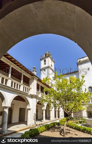 Detail of the Renaissance cloister, with roman arches, Doric columns and the bell tower in the background, of the Monastery of Saint Mary of Lorvao, Coimbra, Portugal