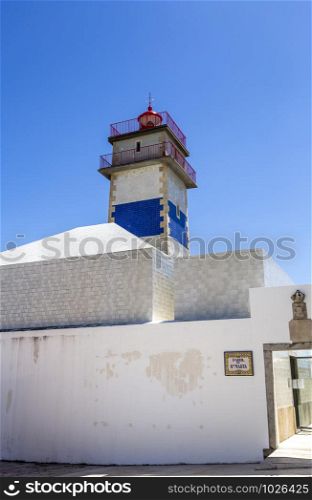 Detail of the top section of the Santa Marta Lighthouse built in 1867, the royal coat of arms and crown and the lighthouse name on a typical Portuguese tiles plate, in Cascais Portugal