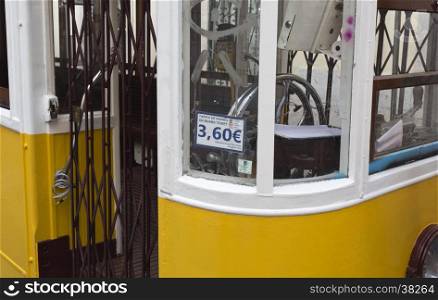 Detail of the tram entry, steering wheel and the exorbitant fare of a minute journey down the street in Lisbon, Portugal